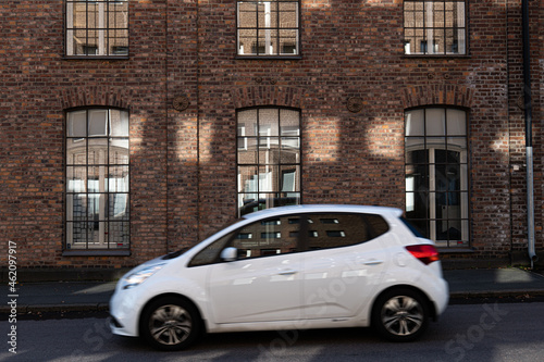 Car driving in front of old industrial brick buildning © Tobias Dahlberg