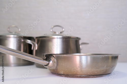 Stainless steel pot, stockpot and frying pan on white table, eco friendly kitchen utensils without harm, harmless safe for people