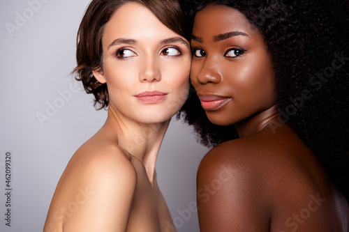 Portrait of two attractive nude women bonding flawless smooth shine skin modern complexion isolated over grey pastel color background