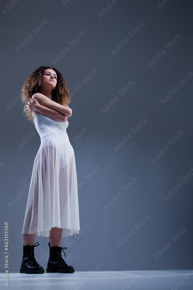 Beautiful girl with curly hair. Ballerina in white dress and black boots. Beautiful girl with curly hair. Ballerina in white dress and black boots.