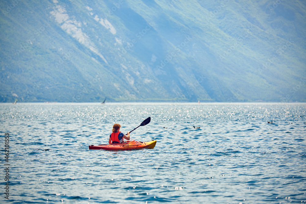 A woman who's having fun in a canoe on the Garda Lake