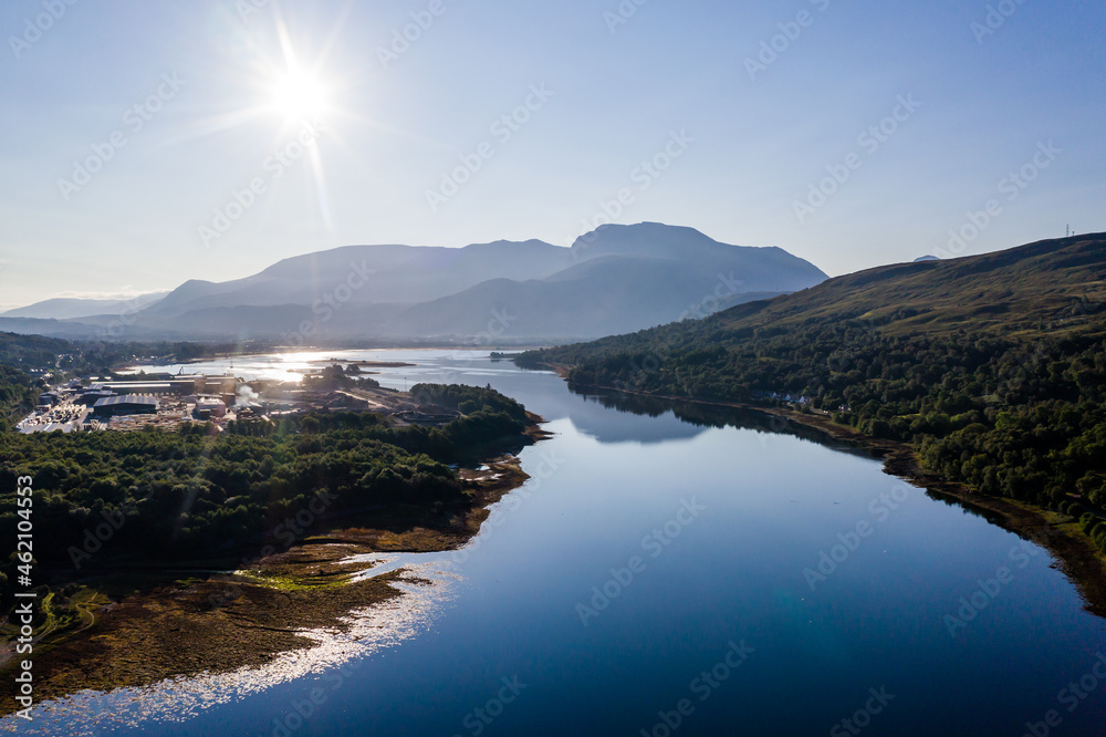 Aerial view of the sun rising above Fort William and the Ben Nevis mountain range in the Scottish Highlands