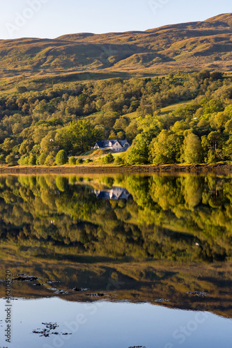 Perfect reflections on a beautiful Scottish Loch in the early morning sunshine (Loch Eil, Fort William) photo