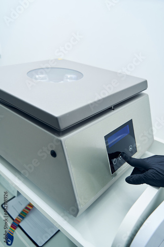 Medical laboratory worker using centrifuge machine in clinic