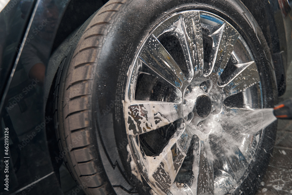 Car wheels washing by high pressure washer