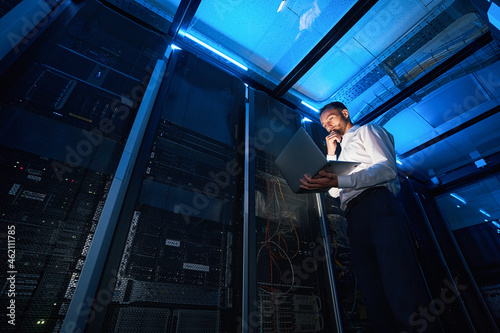 Wallpaper Mural IT technician analyzing data from laptop in server room Torontodigital.ca