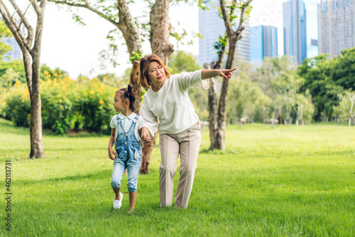 Portrait of happy love asian grandmother and little asian cute girl enjoy relax in summer park.Young girl with their laughing grandparent smiling together.Family and togetherness © Art_Photo