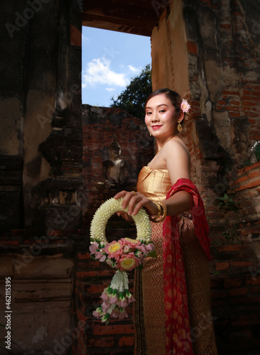 Happy woman wearing Thai traditional dress show Jasmine garland with smiling