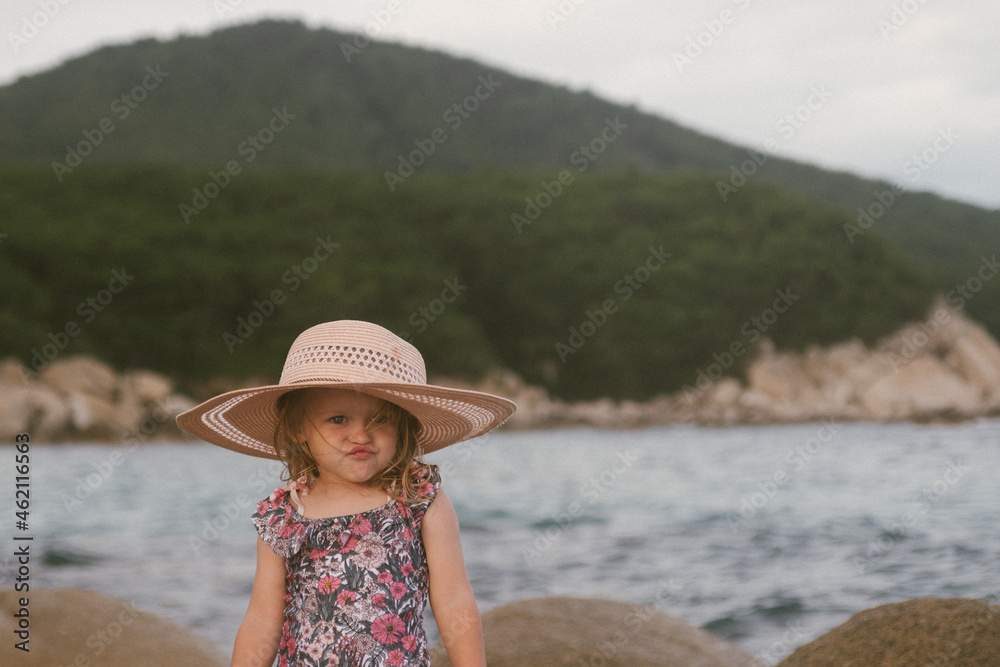smiling girl on the sea in a hat