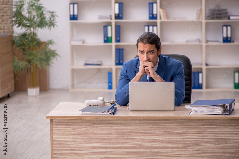 Young male employee sitting in the office Young male employee sitting in the office