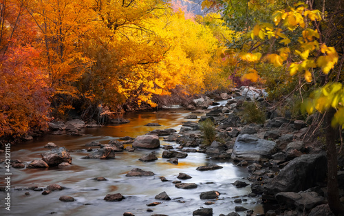 Running water in Ogden river with bright autumn tree reflections in Utah photo