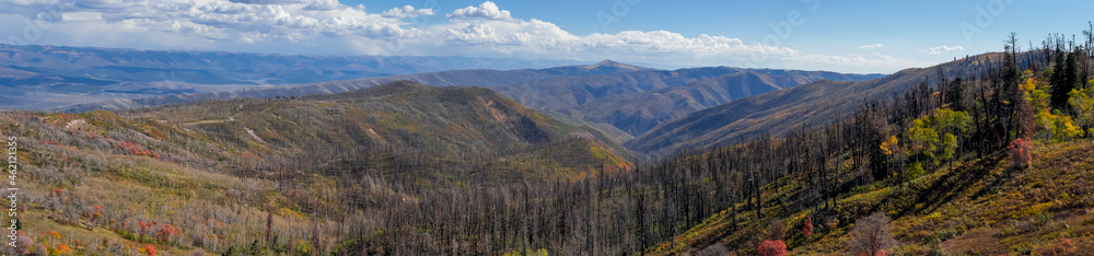 Panoramic view of Wasatch mountain range with burnt trees during wild fires in Utah