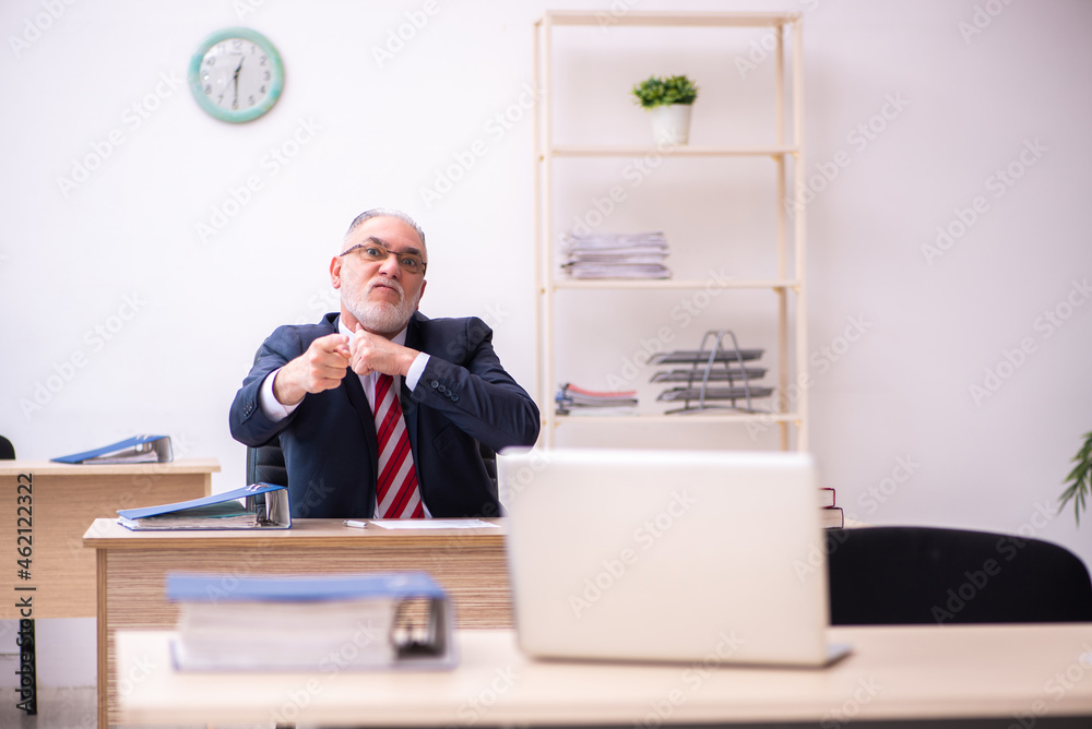 Old businessman employee sitting in the office Old businessman employee sitting in the office