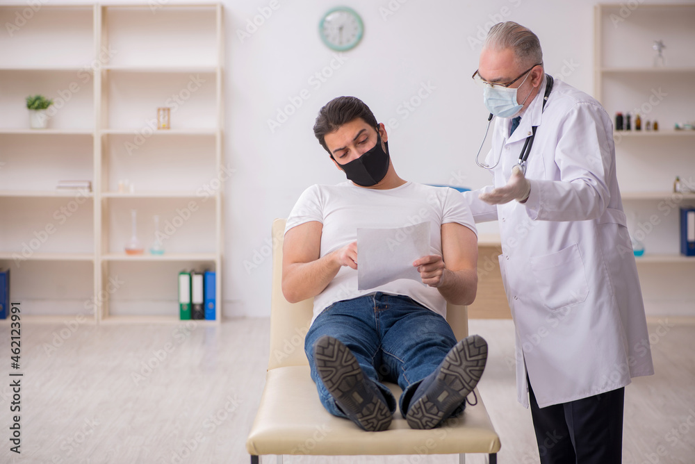 Obraz premium Young male patient visiting old doctor in vaccination concept