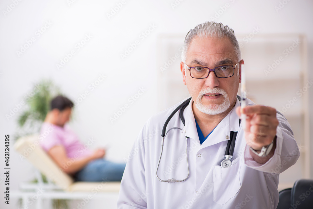 Old male doctor and young male patient in vaccination concept - obrazy, fototapety, plakaty 