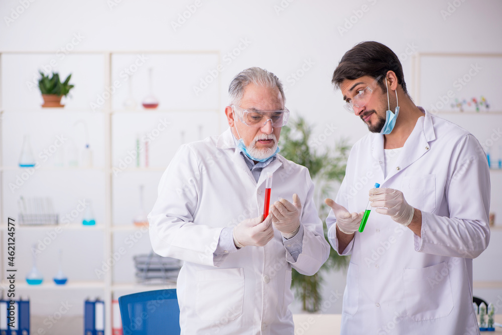 Two male chemists in drugs synthesis concept at the lab Two male chemists in drugs synthesis concept at the lab