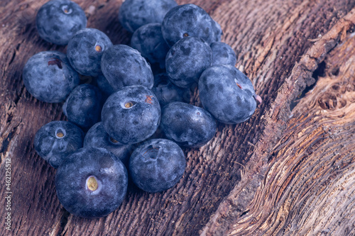 Fresh blueberries on a tree bark.