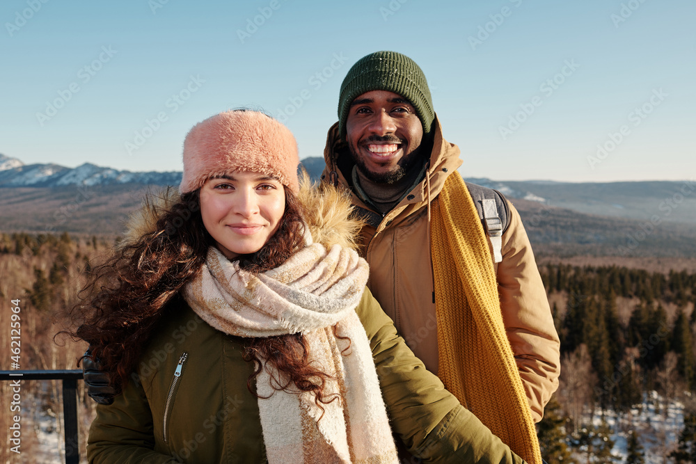 Happy young intercultural couple enjoying winter day in natural environment