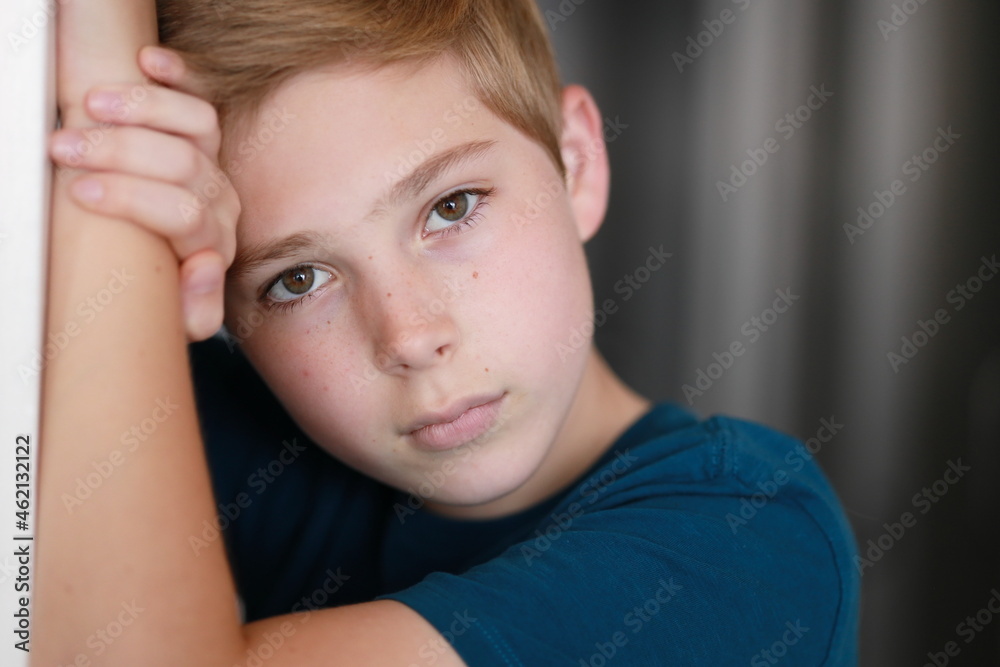Portrait of casual young boy with face posing against arm, looking at the camera. One person. Family, model, childhood concept. Portrait of casual young boy with face posing against arm, looking at the camera. One person. Family, model, childhood concept.