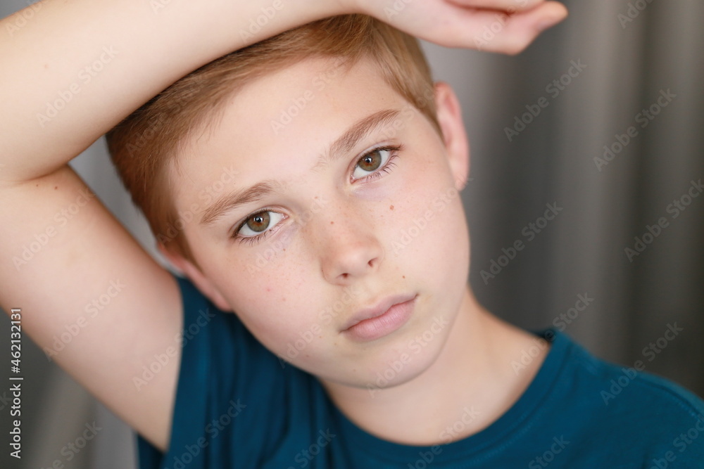 Portrait of casual young boy with face posing against arm, looking at the camera. Family, model, childhood concept. Portrait of casual young boy with face posing against arm, looking at the camera. Family, model, childhood concept.