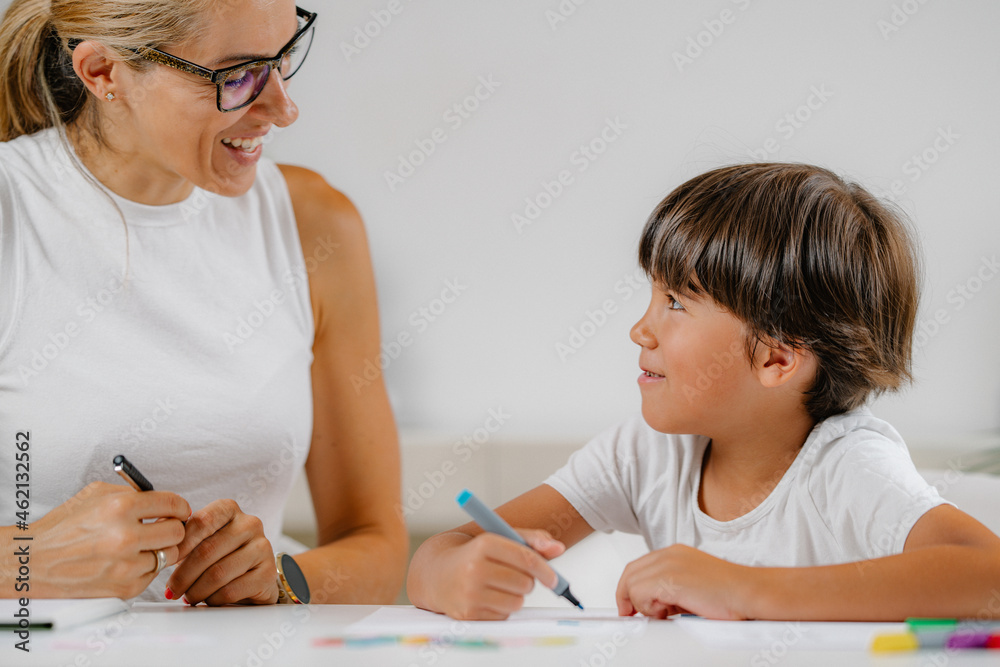 Child coloring shapes in a preschool assessment test.