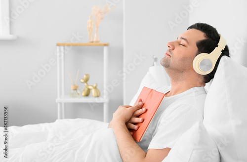 Young man with book listeni...
