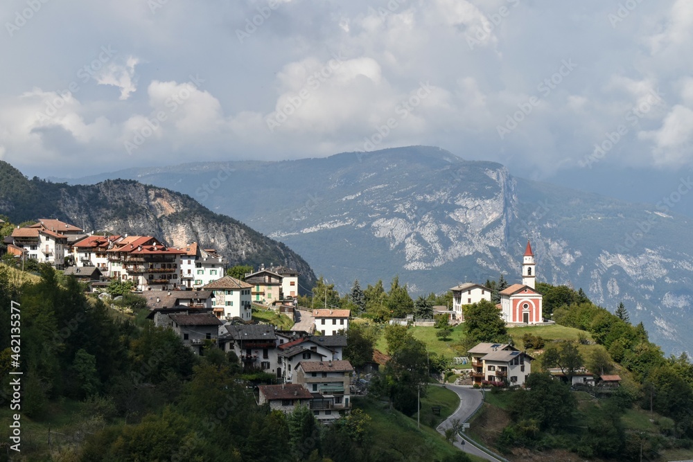 La Guardia frazione di Folgaria in Trentino chiesa illuminata dal sole sfobndo delle Dolomiti di Brenta