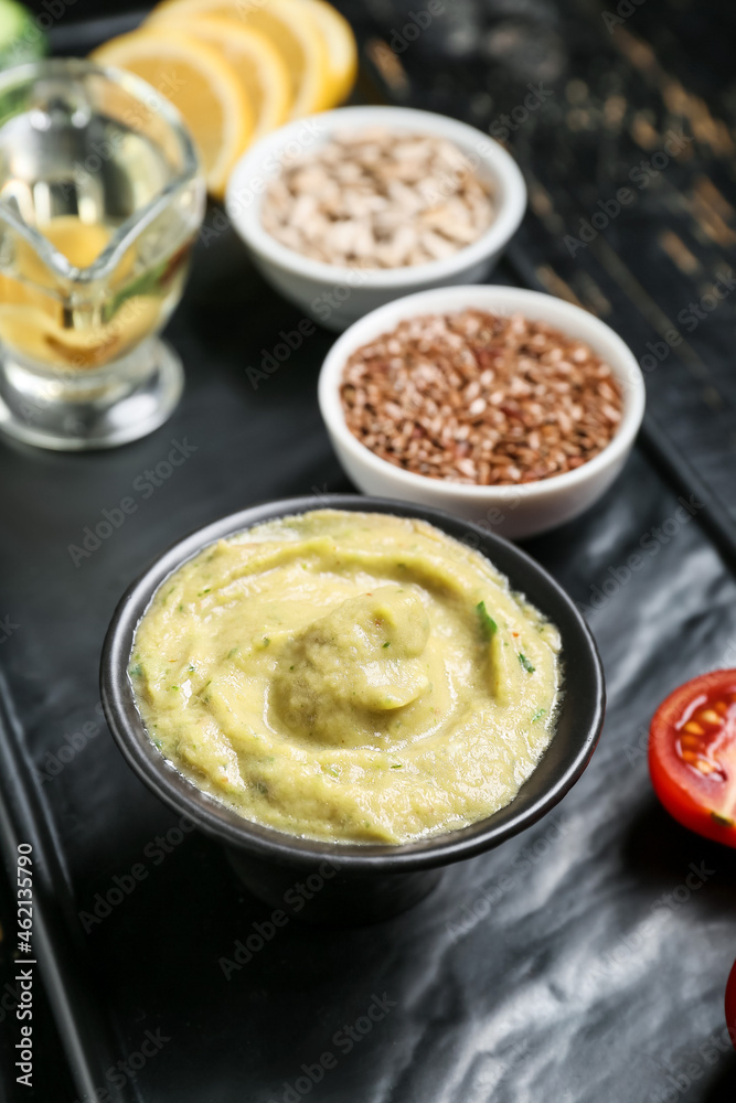 Bowl with tasty baba ghanoush on black table, closeup Bowl with tasty baba ghanoush on black table, closeup