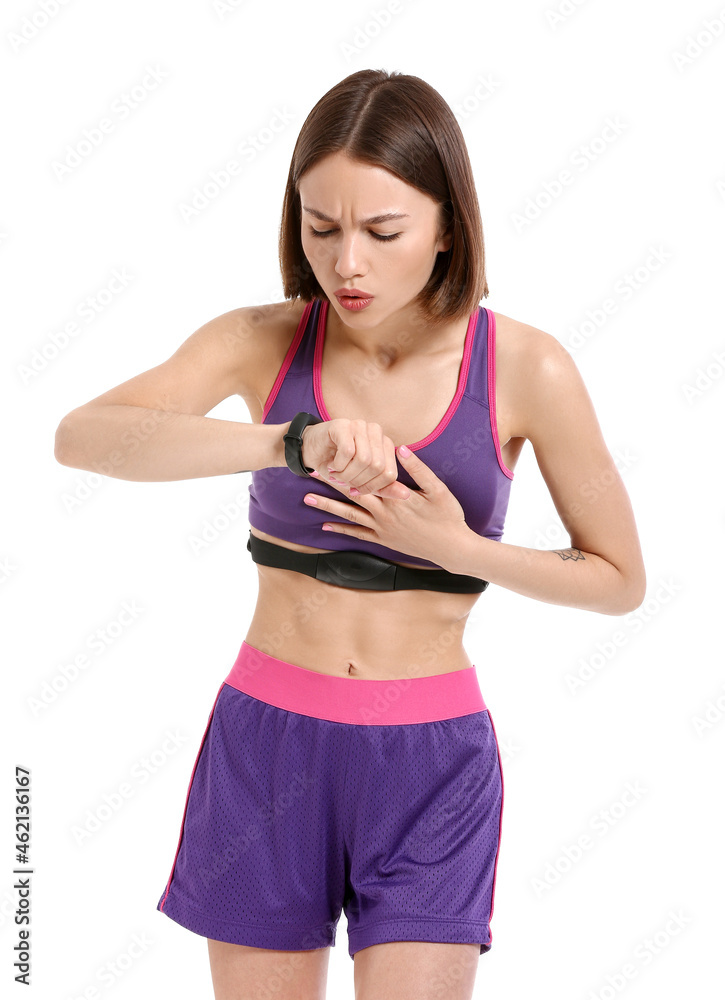 Sporty female runner checking pulse on white background