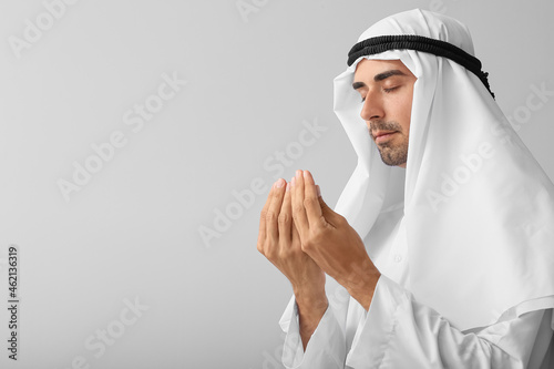 Praying Muslim man on grey ...