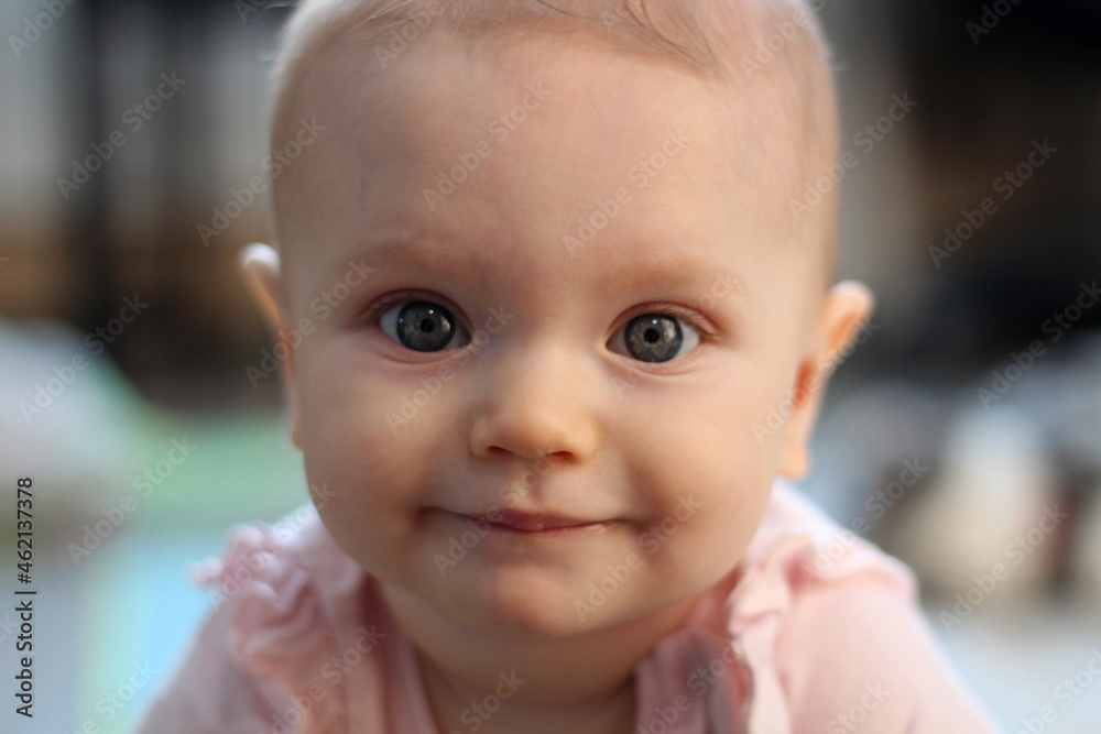 portrait of 8 month old smiling girl. touching and cute indoor photo. solar lighting. portrait in front.