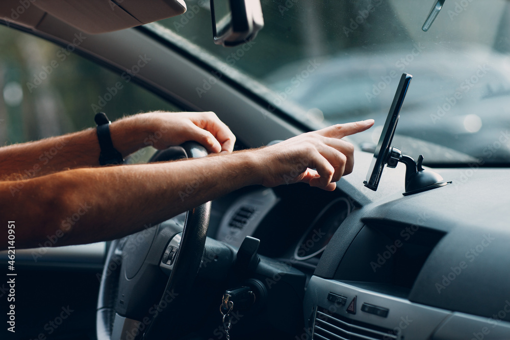 Naklejka premium Navigator in car vehicle transportation commuter. Driver man using mobile phone navigator app driving car.