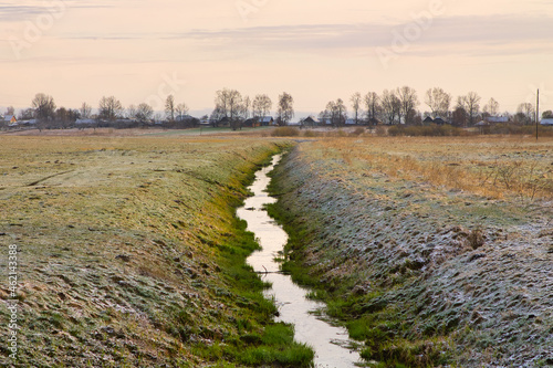 irrigation ditch near a small village in autumn photo