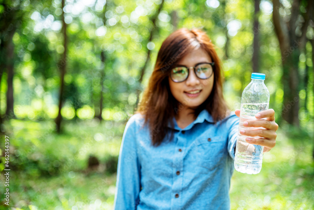 Young Woman Drinking Water from bottle in green garden Park. Asian female drinking water bottle healthy person happy and smiling. Happiness Beautiful asian chinese women holding mineral water bottle Young Woman Drinking Water from bottle in green garden Park. Asian female drinking water bottle healthy person happy and smiling. Happiness Beautiful asian chinese women holding mineral water bottle