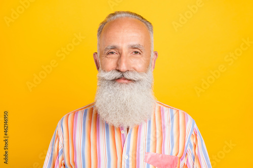 Photo of pretty cheerful mature man dressed yellow shirt smiling isolated yellow color background