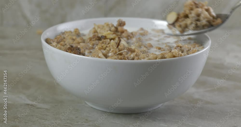 Eating a spoonful of organic almond granola with milk slow motion Eating a spoonful of organic almond granola with milk slow motion