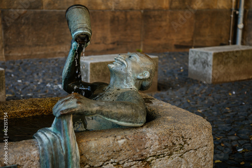 Goerlitz, Saxony, Germany, 04 September 2021: Fountain Das Zecherpaar or reveler couple, stone bath with sculptures of man with mug of beer and woman washing clothes in medieval city at summer day