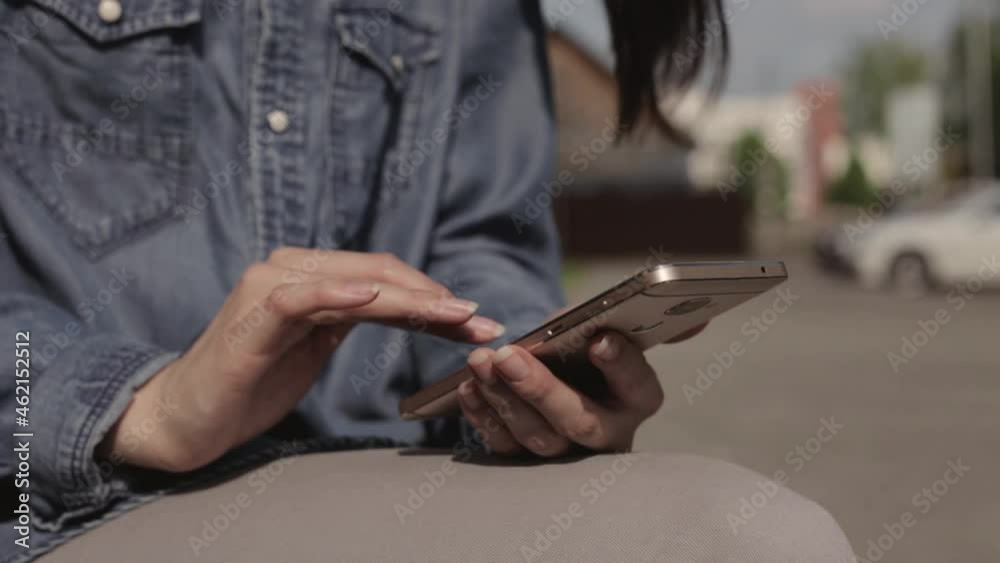 Crop woman messaging on social media and browsing smartphone as freelancer while working in city on sunny day Crop woman messaging on social media and browsing smartphone as freelancer while working in city on sunny day