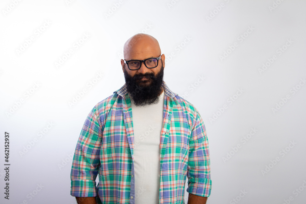 Obraz premium Indian bald man wearing casual clothes and glasses looking at camera and smiling 