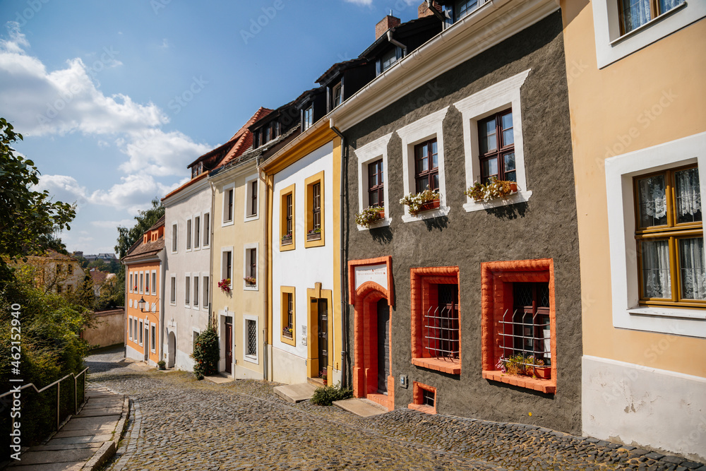 Fototapeta premium Goerlitz, Saxony, Germany, 04 September 2021: Narrow picturesque street with colorful buildings in historic center in medieval city, renaissance and baroque historical buildings at summer sunny day