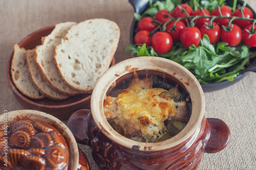 roast in a clay pot with bread and tomatoes