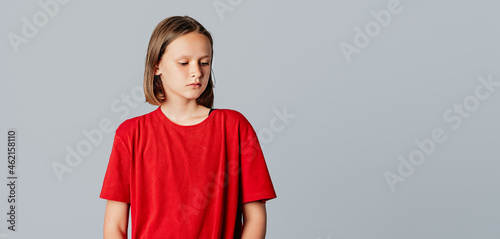 upset brunette teen girl looks away like she is very disappointed, very sad or doesn't want to hear anything, standing over gray background. Copy space