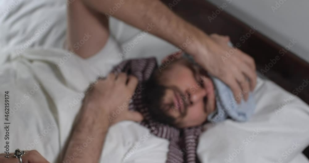 Close up of caucasian bearded man caught a cold lying in bed with white linens in light room suffering from flu. Attractive guy coughing and sneezing , measuring temperature, 4K Close up of caucasian bearded man caught a cold lying in bed with white linens in light room suffering from flu. Attractive guy coughing and sneezing , measuring temperature, 4K