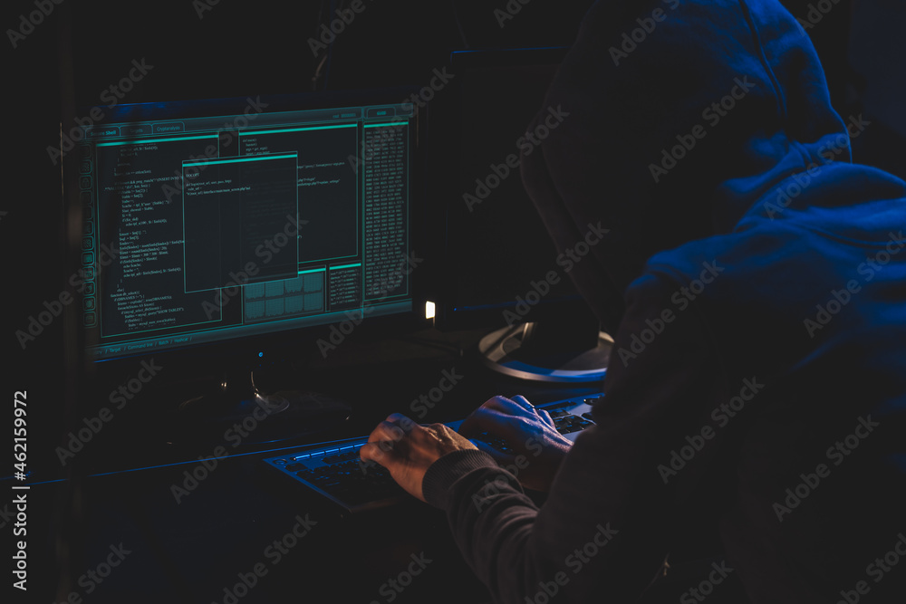 Fotka „Cyber criminal hacking system at monitors, hacker hands at work ...