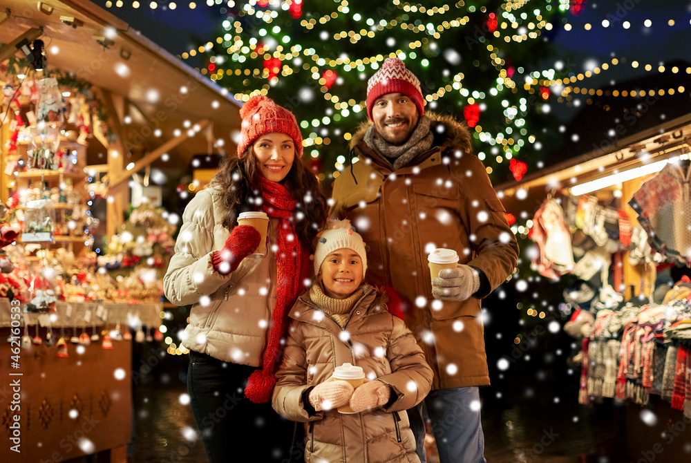 family, winter holidays and celebration concept - happy mother, father and little daughter with takeaway drinks at christmas market on town hall square in tallinn, estonia over snow family, winter holidays and celebration concept - happy mother, father and little daughter with takeaway drinks at christmas market on town hall square in tallinn, estonia over snow