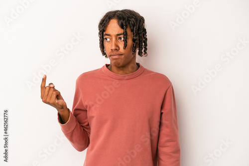 Young african american man isolated on white background pointing with finger at you as if inviting come closer.