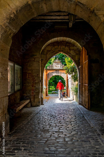 people enjoy bicycle ride along the romantic street in Bavaria near medieval city of Rothenburg