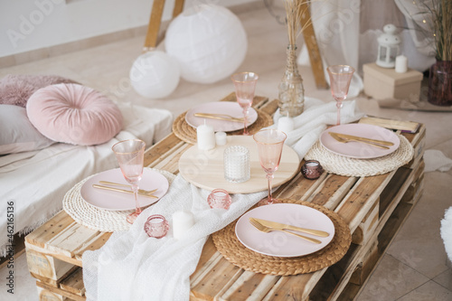 Boho rustic banquet decorated served table for celebration. Birthday party, babyshower, bachelorette party, wedding, luxuary style. White and pink dishes, candels, textyle. photo