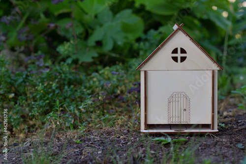 A model of a wooden house on the green grass. Close-up. Family values. Place for your text. © Евгения Надежина