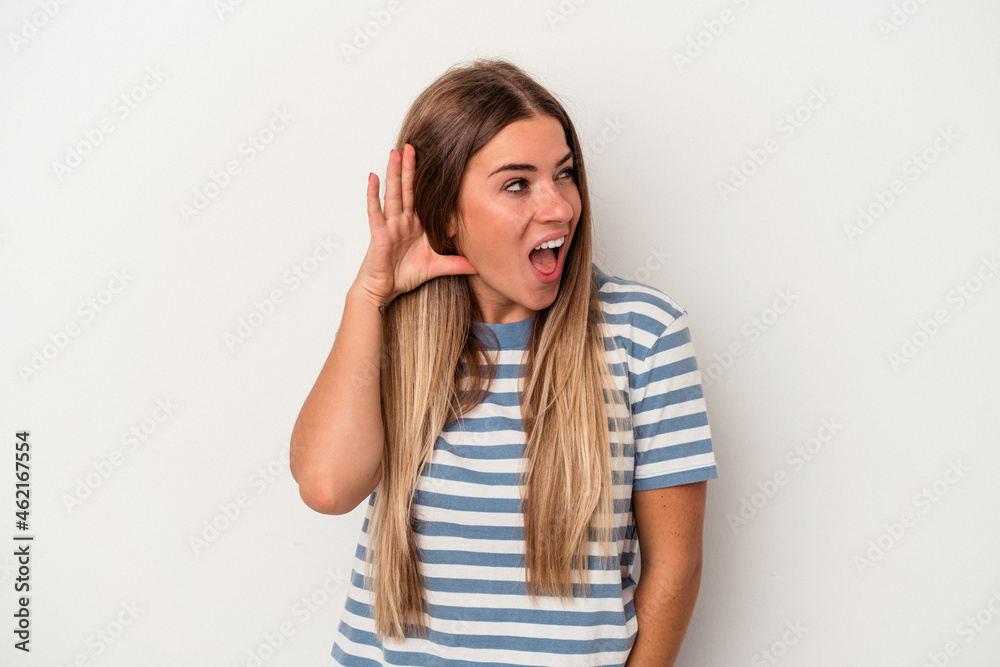 Young Russian woman isolated on white background blink at the camera through fingers, embarrassed covering face. Young Russian woman isolated on white background blink at the camera through fingers, embarrassed covering face.